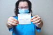 woman is holding a vaccination record card and corona virus vaccine vials. Passport of immunity to the coronavirus in the hands. Health passport as proof of recovery from COVID-19.