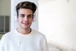 © Giorgio Fochesato/Westend61 - Smiling young man listening music through headphones against column in new home