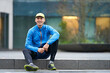 © Jakob Helbig/Westend61 - Smiling mature man wearing cap while sitting on pathway