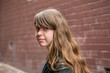 © Clare Seibel-Barnes/Austockphoto - Young teen girl with a fringe in an alleyway looking sad