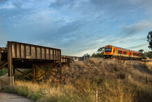 Passenger Train About To Cross A Bridge Over The Highway