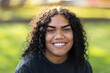 © Caro Telfer/Austockphoto - smiling young woman wearing black against green grass background