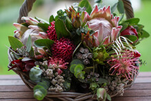 Native Floral Arrangement In Wicker Basket Sitting On Verandah