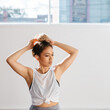 © Jodie Johnson/Austockphoto - Portrait of a beautiful girl putting hair up in a dance studio