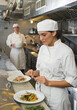 © Tetra Images/Tetra Images - Chef and cook preparing food in commercial kitchen
