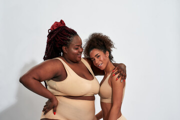 Happy young plump woman hugging with slim girl