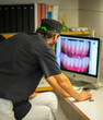 © Cavan Images - Dentist checking photos at Dental Clinic
