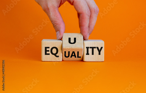Equality or equity symbol. Businessman turns a cube and changs the word \'equality\' to \'equity\'. Beautiful orange background. Psychology, business and equality or equity concept. Copy space.