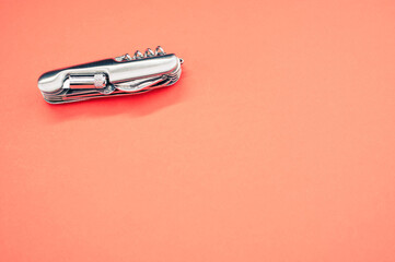 Poster - Isolated shot of the multifunctional pocket knives on a pink background