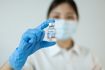 COVID-19 vaccine concept. Doctor in medical gloves holding a coronavirus vaccine bottle.