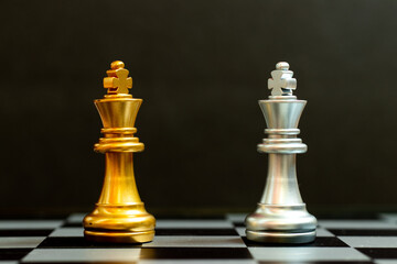 Wall Mural - Gold king in chess game face with the another silver king on black background (Concept for company strategy, business victory or decision)