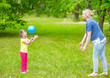 © Ermolaev Alexandr - Little girl with syndrome down and her mother play with a ball in a summer park