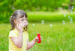 © Ermolaev Alexandr - Girl with syndrome down blows bubbles in a summer park