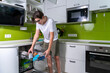 teen boy loading dishwasher in home kitchen. using a dishwasher at home