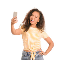 Wall Mural - Young woman with mobile phone taking selfie on white background