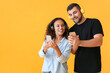 © Pixel-Shot - Young couple with mobile phones and headphones on color background