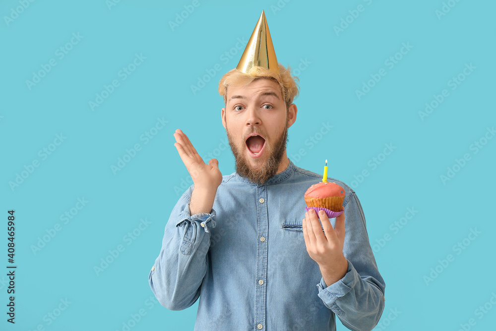Young man celebrating birthday on color background