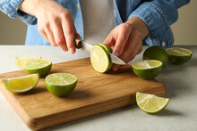 Woman Cuts Lime On Cutting Board, Front View