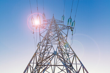 Wall Mural - Power line pylon with sun flare. Industrial background.