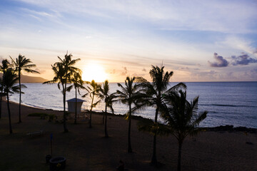 Little lifeguard cottage between palm trees on a Caribbean beach on Hawaii with a colorful view of the calm sea at sundown