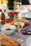 Fototapeta Uliczki - Set up table with white wine and appetizers