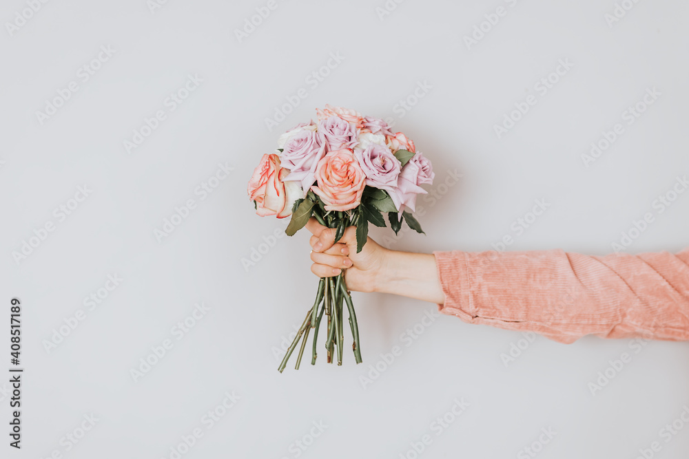 In the hand a bunch of flowers against a white background. Valentine's day gift. Present a bouquet of flowers, Woman day gift, 8 march - obrazy, fototapety, plakaty 
