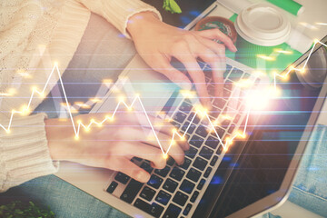 Double exposure of woman hands typing on computer and forex chart hologram drawing. Stock market invest concept.