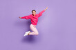 © deagreez - Full size profile side photo of happy cheerful young woman jump up air hands wings isolated on violet color background