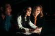 © StratfordProductions - Multiethnic group of business people working with laptop late at night in their office