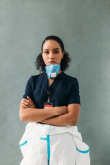 Wall Mural - Confident nurse with medical respirator under her chin looking at camera