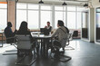 © xartproduction - Group of young business people working and communicating while sitting at the office desk together with colleagues sitting. business meeting