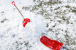 View of a red shovel in snow and red sledge in winter