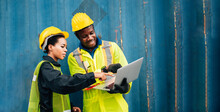 Workers Teamwork Man And Woman In Safety Jumpsuit Uniform With Yellow Hardhat And Use Laptop Check Container At Cargo Shipping Warehouse. Transportation Import,export Logistic Industrial Service