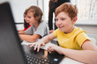 © kegfire - Excited boy working with laptop in classroom