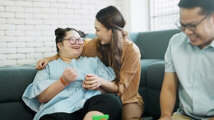 Wall Mural - Happy Down syndrome girl doing activity happily with parent. happy family father and mother take care adopted daughter down syndrome girl spend time together family doing activity together with smile.