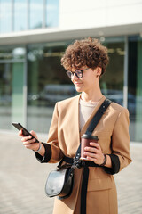 Sticker - Young serious brunette businesswoman with coffee scrolling through contacts