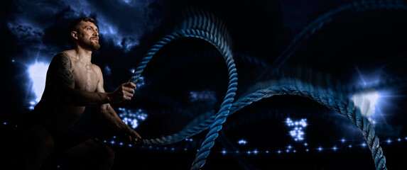 Wall Mural - Muscular man working out with battle ropes