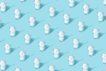 Pastel blue background pattern made of glasses with white hearts and pink paper straw. Minimal summer drink concept. Retro style.