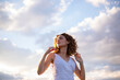 © Cavan Images - curly hair woman outdoors sky background