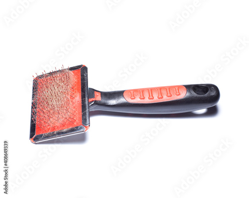 Comb for combing hair from an animal. In the comb is a bunch of Bengal cat hairs © injenerker