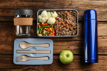 Wall Mural - Flat lay composition with thermos and lunch box on wooden background