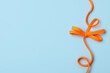 Orange shoelace on light blue background, top view. Space for text