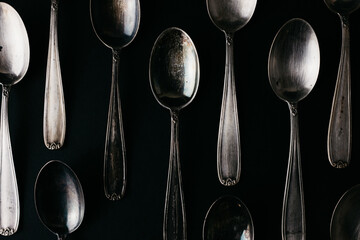 Vintage silver spoons on the black background