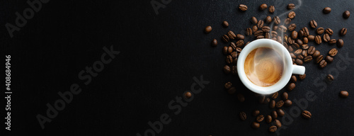 Steaming espresso served in cup on dark © nerudol