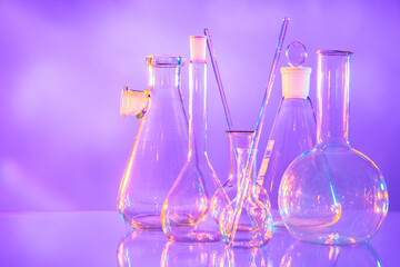 Poster - Laboratory glassware as a symbol of scientific activity. Laboratory glassware on a light background. Test tubes and different shapes stand side by side. Concept - manufacture of laboratory glassware.