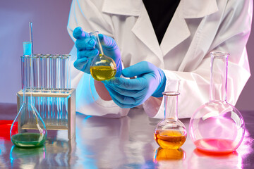 Laboratory testing. A test tube in the hands of a physician as a symbol of laboratory testing of drugs. Pharmacologist is engaged in laboratory testing. Doctor's hands with a small flask.