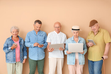 Canvas Print - Senior people with different devices near color wall in room