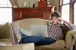 © SuperStock - Man at home using a laptop, working.