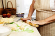 © nadezhda - An elderly woman prepares pies from the dough. Close-up hands hold a rolling pin.
