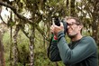 © SuperStock - Ecuador, Galapagos Islands, Man taking pictures with digital camera on hike in jungle